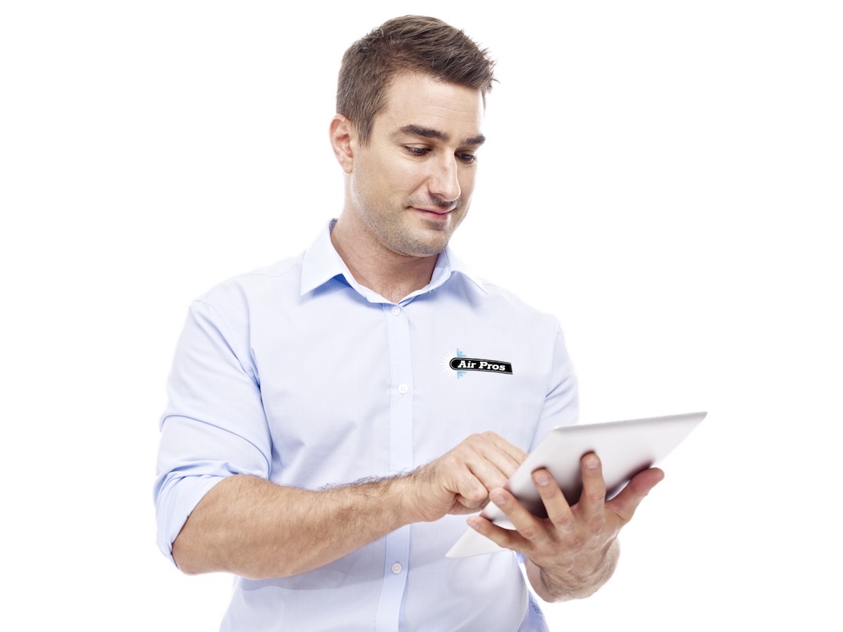 Man in a light blue "Air Pros" shirt uses a digital tablet, tackling HVAC challenges while standing against a plain white background.